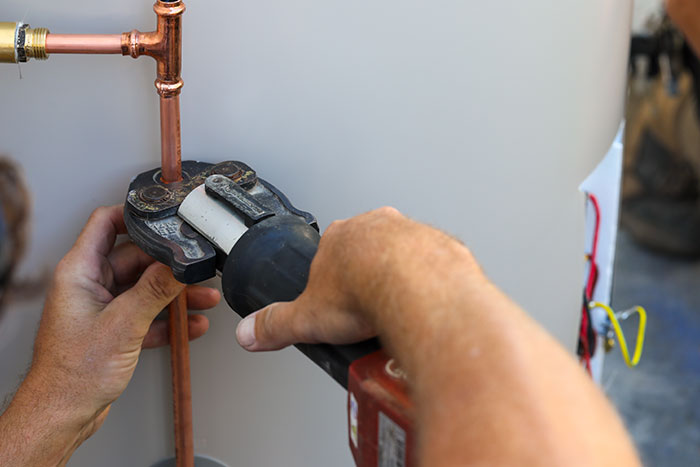 Plumber fitting copper pipes on a hot water system in Gympie